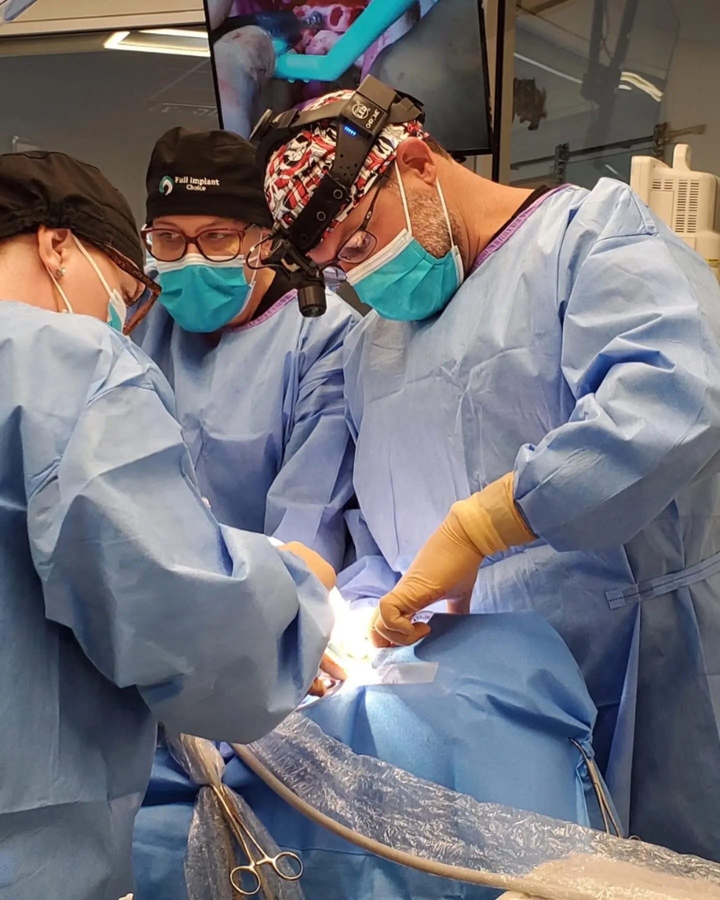 Dr. Adam Hogan in surgical loupes performing a live full-arch case